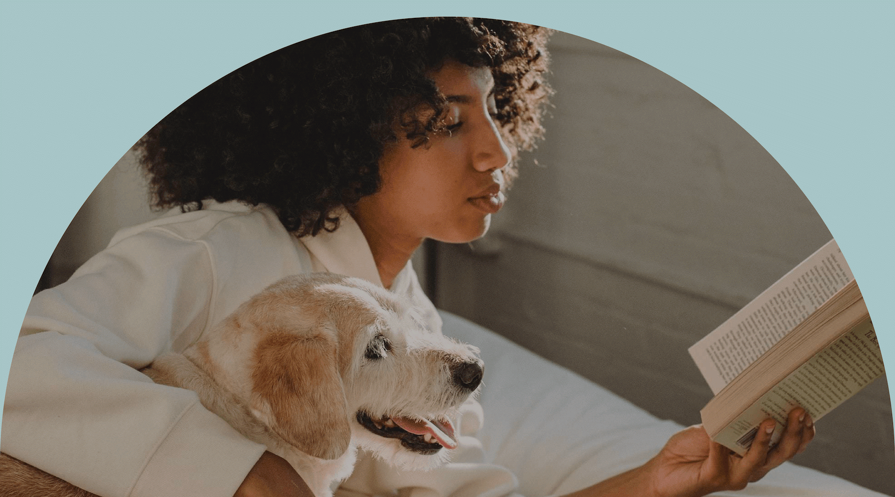 a woman holding a dog and reading a book